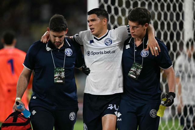 Independiente Rivadavia's Paraguayan defender #40 Ivan Villalba leaves the pitch with assistance after suffering an injury during the first leg of the Copa Libertadores round of 16 football match between Brazil's Fluminense and Argentina's Independiente Rivadavia at the Maracana stadium in Rio de Janeiro, Brazil, on August 11, 2026. (Photo by MAURO PIMENTEL / AFP)