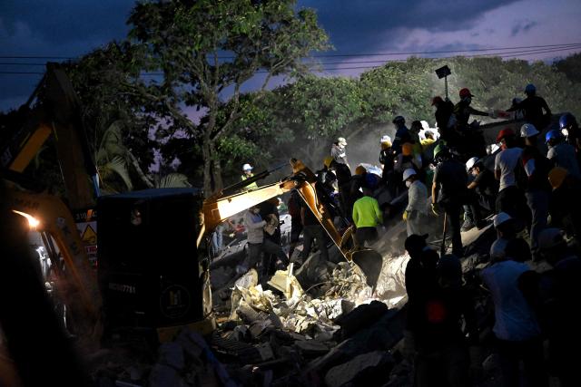 Rescuers and volunteers search for survivors amid the rubble of a collapsed building after an earthquake in Cali, Colombia on August 11, 2026. Colombian volunteers and rescuers cleared rubble with their bare hands to search for survivors early on August 11 after the country's strongest earthquake in a decade killed at least 169 people and smashed dozens of buildings. (Photo by Joaquin SARMIENTO / AFP)