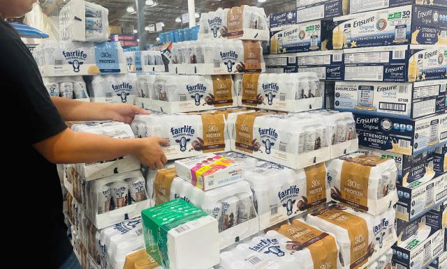 A shopper reaches for a tray of milk at a wholesale retailer in Alhambra, California on August 11, 2026. Stock markets mostly rose on August 10 as investors pared their bets on an interest rate hike by the Federal Reserve that curtail growth, awaiting inflation data this week for more clues to the outlook for the world's biggest economy. (Photo by Frederic J. BROWN / AFP)