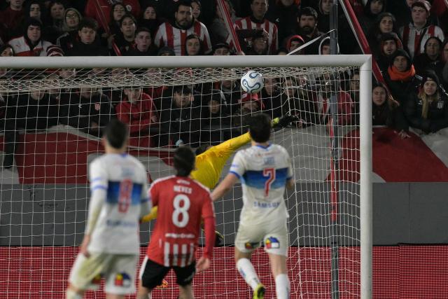 Estudiantes' Uruguayan goalkeeper #16 Fernando Muslera fails to stop a goal by Universidad Catolica's Argentine forward #9 Fernando Zampedri (out of frame) during the first leg of the Copa Libertadores round of 16 football match between Argentina's Estudiantes de La Plata and Chile's Universidad Catolica at the Jorge Luis Hirschi stadium in La Plata, Buenos Aires province, Argentina on August 11, 2026. (Photo by JUAN MABROMATA / AFP)