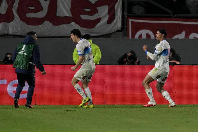 Universidad Catolica's Argentine forward #9 Fernando Zampedri (R) celebrates next to teammate Argentine midfielder #7 Justo Giani after scoring his team's first goal during the first leg of the Copa Libertadores round of 16 football match between Argentina's Estudiantes de La Plata and Chile's Universidad Catolica at the Jorge Luis Hirschi stadium in La Plata, Buenos Aires province, Argentina on August 11, 2026. (Photo by JUAN MABROMATA / AFP)