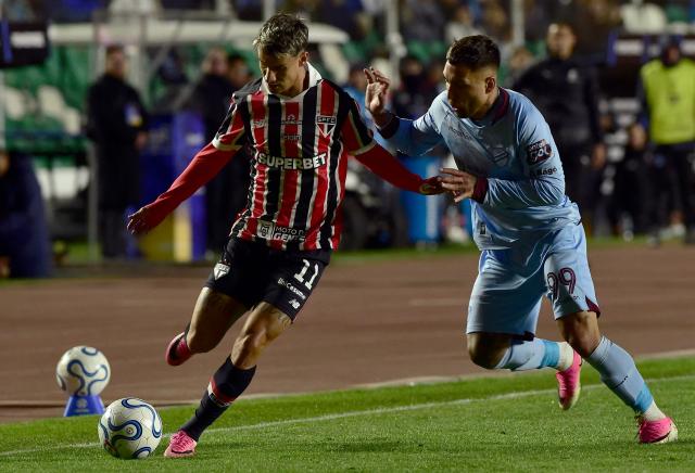 Sao Paulo's forward #11 Ferreira and Bolivar's Argentine forward #99 Damian Batallini fight for the ball during the first leg of the Copa Sudamericana round of 16 football match between Bolivia's Bolivar and Brazil's Sao Paulo, at the Hernando Siles stadium in La Paz, on August 11, 2026. (Photo by Jorge BERNAL / AFP)