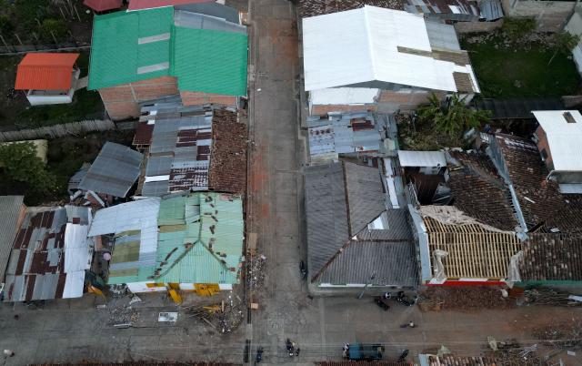 Aerial view shows destroyed houses after an earthquake in El Cairo, Valle del Cauca, Colombia on August 11, 2026. Rescuers, soldiers and volunteers searched through collapsed apartment blocks and office buildings across western Colombia, racing to find survivors after the country's strongest earthquake in a century killed at least 241 people and left many more homeless. (Photo by Raul ARBOLEDA / AFP)