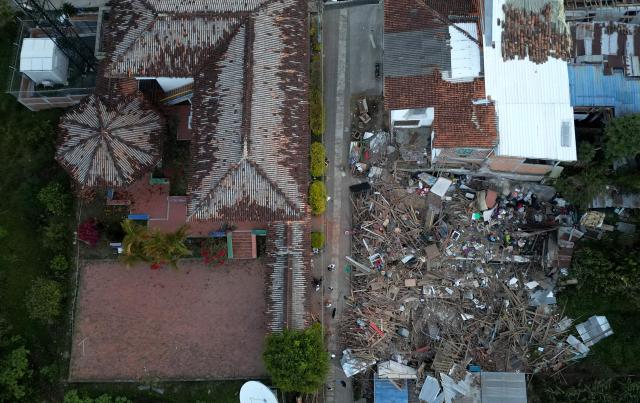 Aerial view shows a destroyed house after an earthquake in El Cairo, Valle del Cauca, Colombia on August 11, 2026. Rescuers, soldiers and volunteers searched through collapsed apartment blocks and office buildings across western Colombia, racing to find survivors after the country's strongest earthquake in a century killed at least 241 people and left many more homeless. (Photo by Raul ARBOLEDA / AFP)