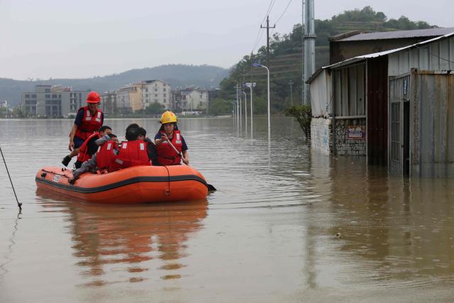 Firefighters rescue workers from a flooded factory following heavy rain in Wenling, eastern China's Zhejiang province on August 12, 2026. (Photo by CN-STR / AFP) / China OUT