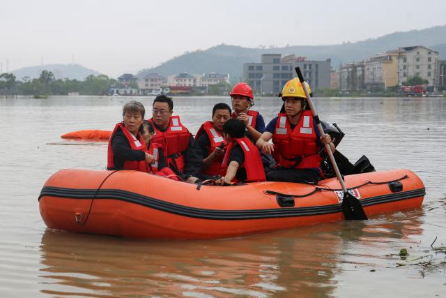 Firefighters rescue workers from a flooded factory following heavy rain in Wenling, eastern China's Zhejiang province on August 12, 2026. (Photo by CN-STR / AFP) / China OUT