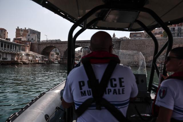 Members of French municipal police marine unit patrol off the Corniche to monitor for people diving from the coastline, in Marseille, on July 31, 2026. Suspended between sea and sky and stretching for three kilometers, the Corniche Kennedy offers a unique city-center setting for daredevil teens. Young divers brave both danger and the authorities leaping into the translucent water - just as they do every summer - while social media attracts new enthusiasts among visiting tourists. (Photo by Thibaud MORITZ / AFP)