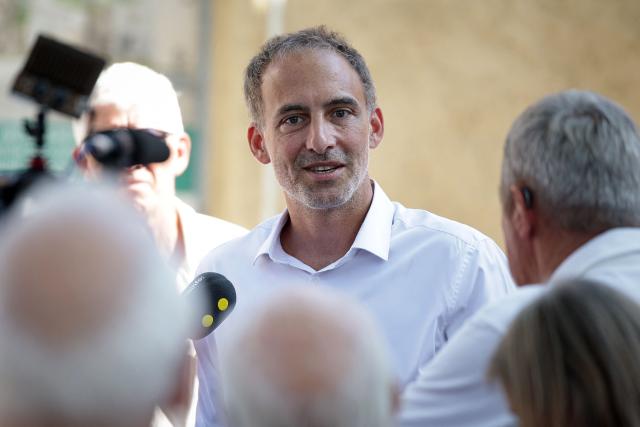 Co-president of French center-left party Place publique (PP) Raphael Glucksmann speaks with journalists as he meets with the residents affected by last year's wildfire, in Jonquiere, south-western France, on August 12, 2026. (Photo by Valentine CHAPUIS / AFP)