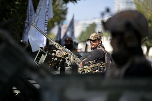 Taliban security personnel stand guard atop armored Humvees along a road in the Green Zone area in Kabul on August 12, 2026 ahead of the fifth anniversary marking their return to power. (Photo by Wakil Kohsar / AFP)