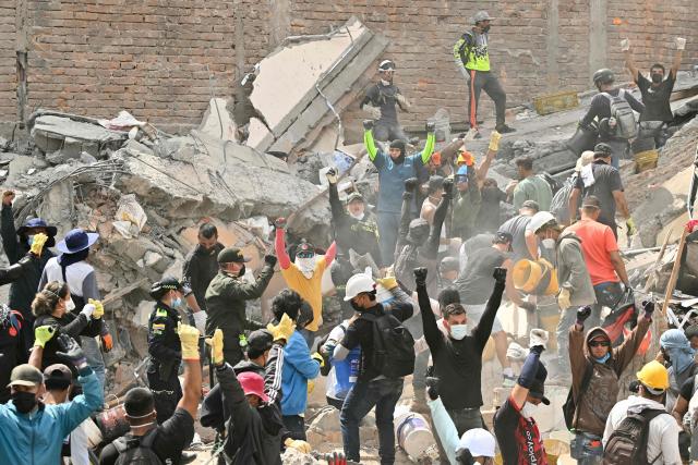 Rescuers call for silence in the search for survivors amid the rubble of a collapsed building after an earthquake in Pereira, Colombia on August 12, 2026. Rescuers, soldiers and volunteers searched through collapsed apartment blocks and office buildings across western Colombia, racing to find survivors after the country's strongest earthquake in a century killed at least 239 people and left many more homeless on August 10, 2026. The 7.4-magnitude quake injured more than 1,670 people, according to a tally by municipal authorities. (Photo by Luis ACOSTA / AFP)