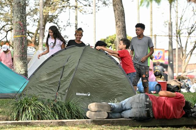 People take shelter in tents after an earthquake in Pereira, Colombia on August 12, 2026. Rescuers, soldiers and volunteers searched through collapsed apartment blocks and office buildings across western Colombia, racing to find survivors after the country's strongest earthquake in a century killed at least 239 people and left many more homeless on August 10, 2026. The 7.4-magnitude quake injured more than 1,670 people, according to a tally by municipal authorities. (Photo by Luis ACOSTA / AFP)