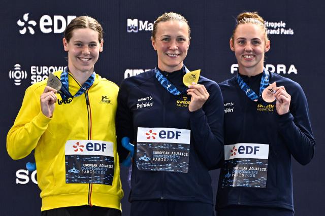 (LtoR) Belgium's Roos Vanotterdijk (silver medal), Sweden's Sarah Sjostrom (gold medal) and Sweden's Sara Junevik (bronze medal) pose on the podium of the women's 50m butterfly swimming event during the LEN European Aquatics Championships at the Olympic Aquatic Centre in Saint-Denis, northern suburbs of Paris, on August 12, 2026. (Photo by JULIEN DE ROSA / AFP)
