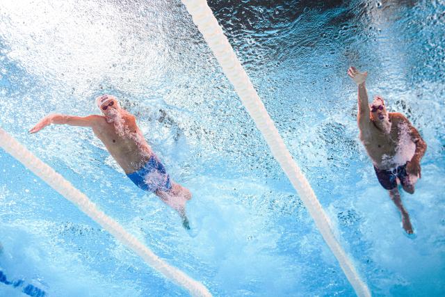 Romania's swimmer David Popovici (L) and Spain's swimmer Luca Hoek Le Guenedal (R) compete during the final of the men's 100m freestyle swimming event during the LEN European Aquatics Championships at the Olympic Aquatic Centre in Saint-Denis, northern suburbs of Paris, on August 12, 2026. (Photo by Sébastien BOZON / AFP)