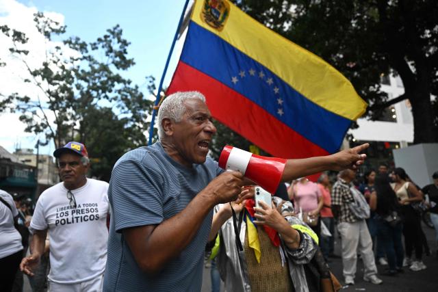A demonstrator takes part in a protest outside the Melia Caracas Hotel during the political dialogue process between representatives of the government and the opposition at the Conventions Center in Caracas on August 12, 2026. (Photo by Juan BARRETO / AFP)