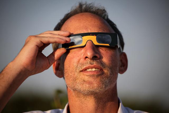 French politician, centre-left party Place publique's leader and MEP Raphael Glucksmann uses solar eclipse viewing glasses to watch the partial solar eclipse, in Bize-Minervois, south-western France, on August 12, 2026. In France, the solar eclipse was not total - after the total solar eclipse of 1999 France will not see another total eclipse for another 55 years in 2081. (Photo by Valentine CHAPUIS / AFP)