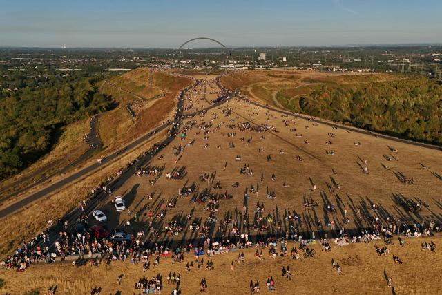 An aerial view shows people watching the solar partial eclipse in the landscape park Halde Hoheward in Herten, western Germany, on August 12, 2026. Millions of people turn their gaze towards the heavens on August 12, 2026 to witness one of nature's greatest spectacles -- a rare total solar eclipse -- as it sweeps over mainland Europe to briefly turn day into night. In Germany, the sun will be between 84 and 90 percent obscured from shortly after 7:00 p.m. until just before 9:00 p.m. (Photo by Ina FASSBENDER / AFP)