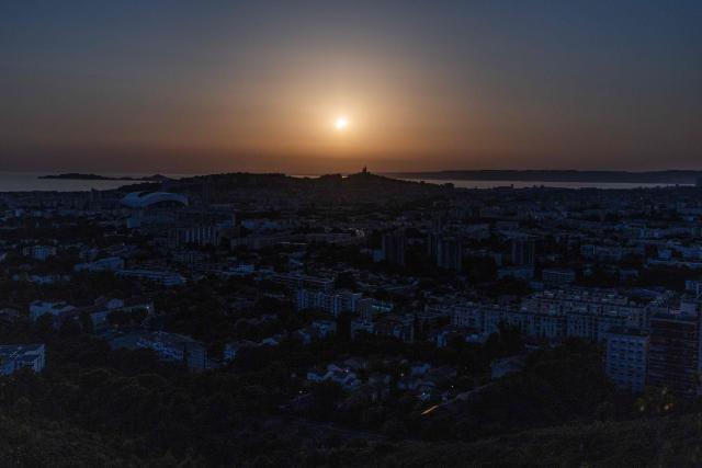 The moon passes in front of the sun's horizon during a partial solar eclipse in Marseille, in southeastern France, on August 12, 2026. In France, the solar eclipse was not total - after the total solar eclipse of 1999 France will not see another total eclipse for another 55 years in 2081. (Photo by Thibaud MORITZ / AFP)