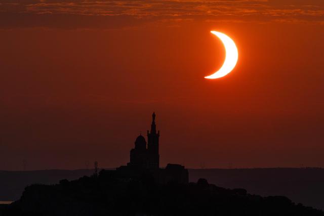 TOPSHOT - The moon passes over the sun's horizon behind the Notre-Dame de la Garde Basilica, nicknamed the “Bonne Mиre,” during a partial solar eclipse in Marseille, in southeastern France, on August 12, 2026. In France, the solar eclipse was not total - after the total solar eclipse of 1999 France will not see another total eclipse for another 55 years in 2081. (Photo by Thibaud MORITZ / AFP)