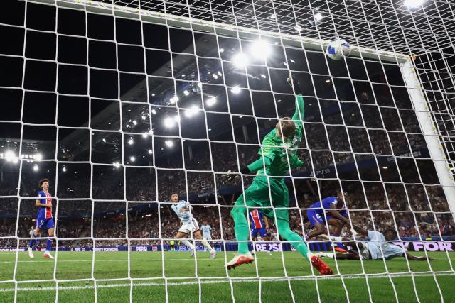 Aston Villa's English striker #39 Brian Madjo (R) scores the 1-1 goal past Paris Saint-Germain's Russian goalkeeper #39 Matvey Safonov during the UEFA Supercup football match between Champions League winners Paris Saint Germain (PSG) and Europa League winners Aston Villa in Salzburg, Austria on August 12, 2026. (Photo by FRANCK FIFE / AFP)