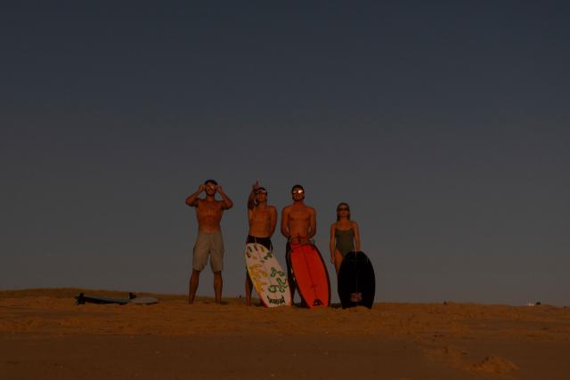 surfers watch a partial solar eclipse in the water in Lege-Cap-Ferret on August 12, 2026. Millions of people turn their gaze towards the heavens on August 12, 2026 to witness one of nature's greatest spectacles -- a rare total solar eclipse -- as it sweeps over mainland Europe to briefly turn day into night. (Photo by Tania Buijten / AFP)