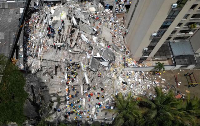This aerial view shows rescuers searching for survivors amid the rubble of a collapsed building after an earthquake in Cali, Colombia on August 12, 2026. Colombia's government on August 12 declared three days of mourning for victims of an earthquake that demolished buildings in the west of the country, killing more than 200 people. (Photo by Raul ARBOLEDA / AFP)