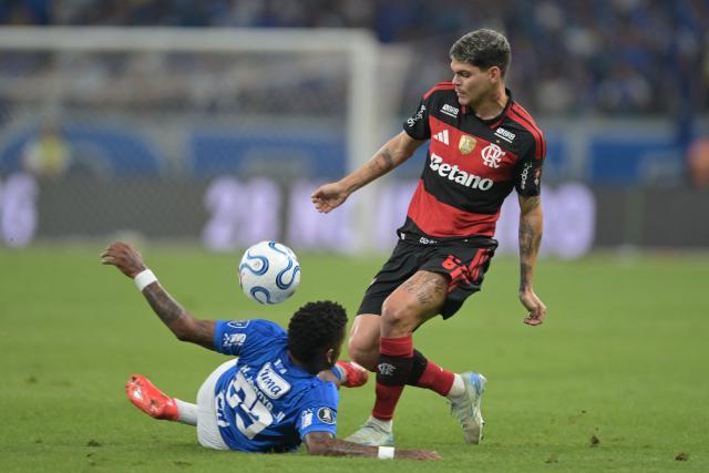 Cruzeiro's Ecuadorean forward Keny Arroyo (L) and Flamengo's defender #06 Ayrton Lucas fight for the ball during the first leg of the Copa Libertadores round of 16 football match between Brazilian teams Cruzeiro and Flamengo at the Mineirao stadium in Belo Horizonte, state of Minas Gerais, Brazil, on August 12, 2026. (Photo by DOUGLAS MAGNO / AFP)