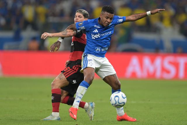Cruzeiro's Ecuadorean forward Keny Arroyo (R) and Flamengo's defender #06 Ayrton Lucas fight for the ball during the first leg of the Copa Libertadores round of 16 football match between Brazilian teams Cruzeiro and Flamengo at the Mineirao stadium in Belo Horizonte, state of Minas Gerais, Brazil, on August 12, 2026. (Photo by DOUGLAS MAGNO / AFP)
