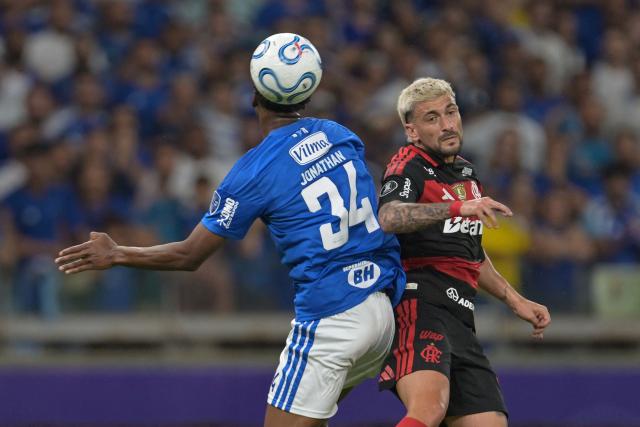 Cruzeiro's defender #34 Jonathan Jesus and Flamengo's Uruguayan midfielder #10 Giorgian de Arrascaeta jump to head the ball during the first leg of the Copa Libertadores round of 16 football match between Brazilian teams Cruzeiro and Flamengo at the Mineirao stadium in Belo Horizonte, state of Minas Gerais, Brazil, on August 12, 2026. (Photo by DOUGLAS MAGNO / AFP)