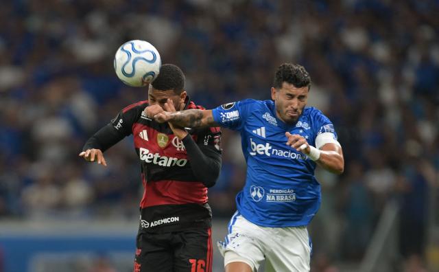 Flamengo's forward #16 Samuel Lino (L) and Cruzeiro's defender #12 William fight for the ball during the first leg of the Copa Libertadores round of 16 football match between Brazilian teams Cruzeiro and Flamengo at the Mineirao stadium in Belo Horizonte, state of Minas Gerais, Brazil, on August 12, 2026. (Photo by DOUGLAS MAGNO / AFP)