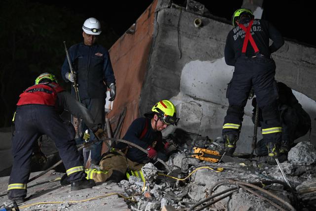 Rescue workers and volunteers remove rubble as they search for survivors at the site of collapsed buildings after an earthquake in Cali, Colombia on August 12, 2026. Rescuers, soldiers and volunteers searched through collapsed apartment blocks and office buildings across western Colombia, racing to find survivors after the country's strongest earthquake in a century killed at least 239 people and left many more homeless on August 10, 2026. The 7.4-magnitude quake injured more than 1,670 people, according to a tally by municipal authorities. (Photo by Raul ARBOLEDA / AFP)