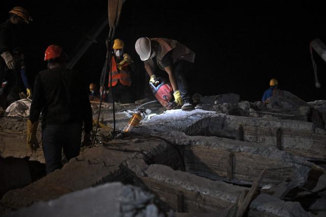 Rescue workers and volunteers remove rubble as they search for survivors at the site of collapsed buildings after an earthquake in Cali, Colombia on August 12, 2026. Rescuers, soldiers and volunteers searched through collapsed apartment blocks and office buildings across western Colombia, racing to find survivors after the country's strongest earthquake in a century killed at least 239 people and left many more homeless on August 10, 2026. The 7.4-magnitude quake injured more than 1,670 people, according to a tally by municipal authorities. (Photo by Raul ARBOLEDA / AFP)