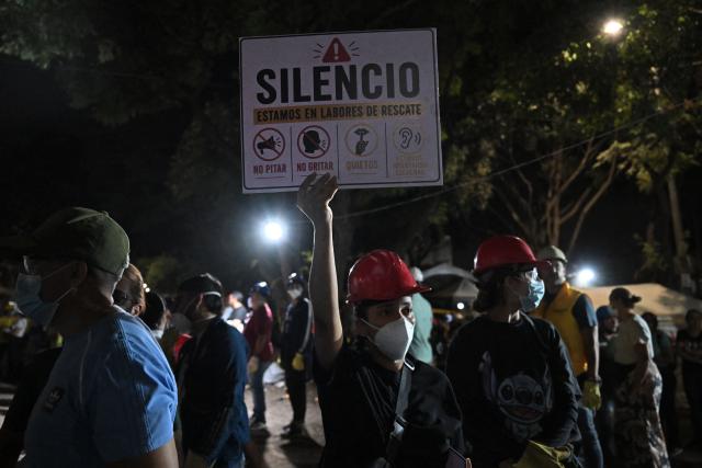Rescue workers ask for silence as they search for survivors at the site of collapsed buildings after an earthquake in Cali, Colombia on August 12, 2026. Rescuers, soldiers and volunteers searched through collapsed apartment blocks and office buildings across western Colombia, racing to find survivors after the country's strongest earthquake in a century killed at least 239 people and left many more homeless on August 10, 2026. The 7.4-magnitude quake injured more than 1,670 people, according to a tally by municipal authorities. (Photo by Raul ARBOLEDA / AFP)