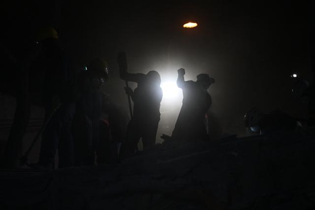 Rescue workers and volunteers remove rubble as they search for survivors at the site of collapsed buildings after an earthquake in Cali, Colombia on August 12, 2026. Rescuers, soldiers and volunteers searched through collapsed apartment blocks and office buildings across western Colombia, racing to find survivors after the country's strongest earthquake in a century killed at least 239 people and left many more homeless on August 10, 2026. The 7.4-magnitude quake injured more than 1,670 people, according to a tally by municipal authorities. (Photo by Raul ARBOLEDA / AFP)