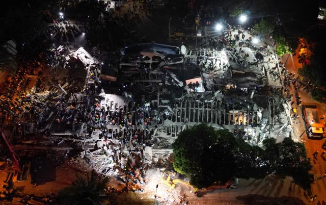 Aerial view of rescue workers and volunteers searching for survivors at the site of collapsed buildings after an earthquake in Cali, Colombia on August 12, 2026. Rescuers, soldiers and volunteers searched through collapsed apartment blocks and office buildings across western Colombia, racing to find survivors after the country's strongest earthquake in a century killed at least 239 people and left many more homeless on August 10, 2026. The 7.4-magnitude quake injured more than 1,670 people, according to a tally by municipal authorities. (Photo by Raul ARBOLEDA / AFP)