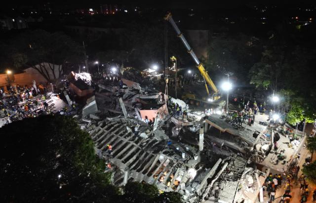 Aerial view of rescue workers and volunteers searching for survivors at the site of collapsed buildings after an earthquake in Cali, Colombia on August 12, 2026. Rescuers, soldiers and volunteers searched through collapsed apartment blocks and office buildings across western Colombia, racing to find survivors after the country's strongest earthquake in a century killed at least 239 people and left many more homeless on August 10, 2026. The 7.4-magnitude quake injured more than 1,670 people, according to a tally by municipal authorities. (Photo by Raul ARBOLEDA / AFP)