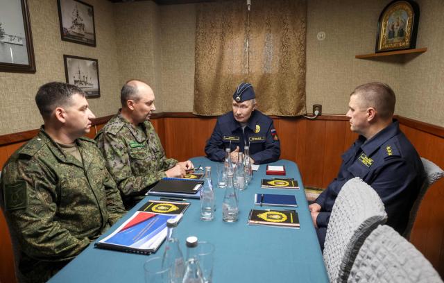 In this pool photograph distributed by the Russian state agency Sputnik, Russia's President Vladimir Putin holds a meeting on ensuring the security of Russia's eastern borders onboard the Russian Navy's guided missile cruiser Varyag on far eastern Sakhalin Island on August 13, 2026. (Photo by Gavriil Grigorov / POOL / AFP)