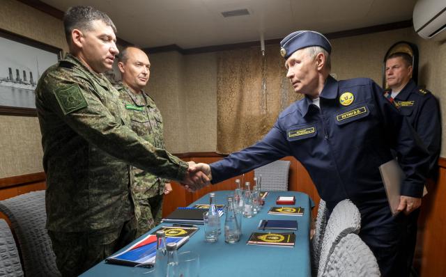 In this pool photograph distributed by the Russian state agency Sputnik, Russia's President Vladimir Putin holds a meeting on ensuring the security of Russia's eastern borders onboard the Russian Navy's guided missile cruiser Varyag on far eastern Sakhalin Island on August 13, 2026. (Photo by Gavriil Grigorov / POOL / AFP)