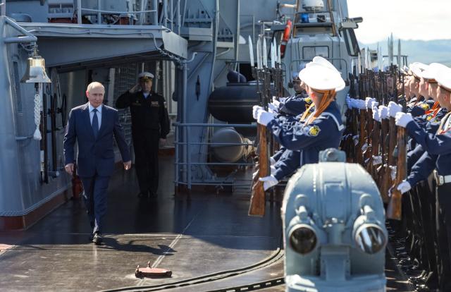 In this pool photograph distributed by the Russian state agency Sputnik, Russia's President Vladimir Putin walks on the deck of the Russian Navy's guided missile cruiser Varyag during the final stage of a Pacific Fleet's naval drills on far eastern Sakhalin Island on August 13, 2026. (Photo by Gavriil Grigorov / POOL / AFP)