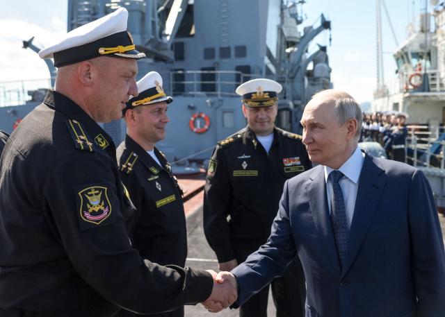 In this pool photograph distributed by the Russian state agency Sputnik, Russia's President Vladimir Putin shakes hands with officers onboard the Russian Navy's guided missile cruiser Varyag during the final stage of a Pacific Fleet's naval drills on far eastern Sakhalin Island on August 13, 2026. (Photo by Gavriil Grigorov / POOL / AFP)
