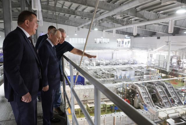In this pool photograph distributed by the Russian state agency Sputnik, Russia's President Vladimir Putin visits the Yasny fish processing factory on Iturup island, one of four islands in the contested chain known as the Kuril Islands in Russia and the Northern Territories in Japan, on August 13, 2026. (Photo by Gavriil Grigorov / POOL / AFP)