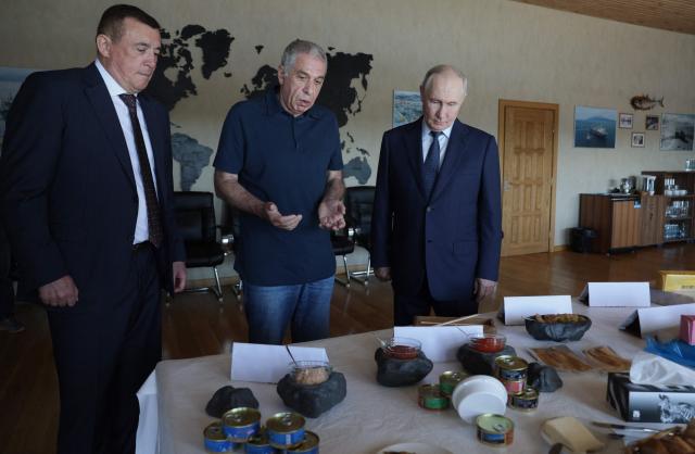 In this pool photograph distributed by the Russian state agency Sputnik, Russia's President Vladimir Putin visits the Yasny fish processing factory on Iturup island, one of four islands in the contested chain known as the Kuril Islands in Russia and the Northern Territories in Japan, on August 13, 2026. (Photo by Gavriil Grigorov / POOL / AFP)