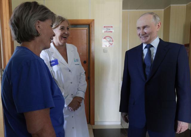 In this pool photograph distributed by the Russian state agency Sputnik, Russia's President Vladimir Putin visits a hospital on Iturup island, one of four islands in the contested chain known as the Kuril Islands in Russia and the Northern Territories in Japan, on August 13, 2026. (Photo by Gavriil Grigorov / POOL / AFP)