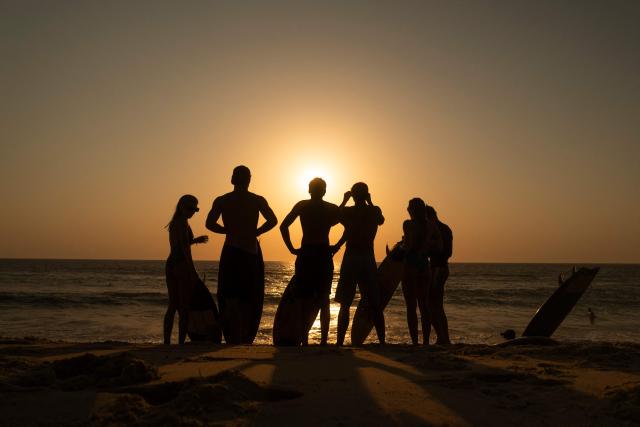 surfers watch a partial solar eclipse From the beach in Lege-Cap-Ferret on August 12, 2026. Millions of people turn their gaze towards the heavens on August 12, 2026 to witness one of nature's greatest spectacles -- a rare total solar eclipse -- as it sweeps over mainland Europe to briefly turn day into night. (Photo by Tania Buijten / AFP)