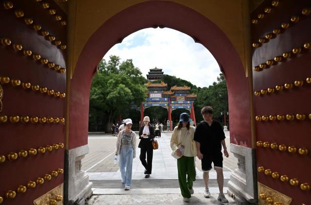 People visit the Jingshan park in Beijing on August 13, 2026. (Photo by Adek BERRY / AFP)