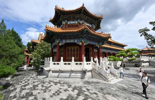 People visit the Jingshan park in Beijing on August 13, 2026. (Photo by Adek BERRY / AFP)