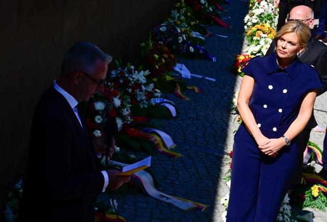 President of the Bundestag Julia Kloeckner and Berlin's mayor Kai Wegner (covered) attend the Central Commemorative Ceremony of the State of Berlin and the Federal Government on the 65th Anniversary of the Construction of the Berlin Wall on August 13, 2026. (Photo by John MACDOUGALL / AFP)