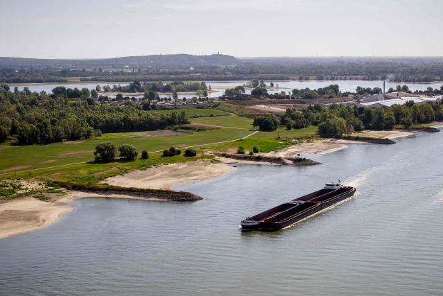 This aerial photograph shows inland vessels sealing of the Rhine in Millingen aan de Rijn on August 12, 2026. The Netherlands, renowned for its resilience in the face of the constant threat of flooding, has been grappling for several months with a historic drought caused by very low rainfall and exceptional heat, which has completely dried out the soil since spring. (Photo by Sem van der Wal / ANP / AFP) / Netherlands OUT