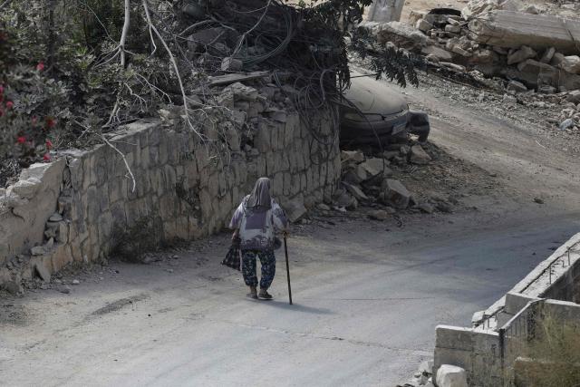 An elderly woman walks past the rubble of destroyed structures in the southern Lebanese village of Zawtar al-Gharbiyah on August 13, 2026. Lebanese Prime Minister Nawaf Salam on August 12 condemned Israel's "systematic destruction" in the country's south as a violation of international law, as Israel's defence minister said its military was "destroying all the houses" there. (Photo by Ammar Ammar / AFP) / 