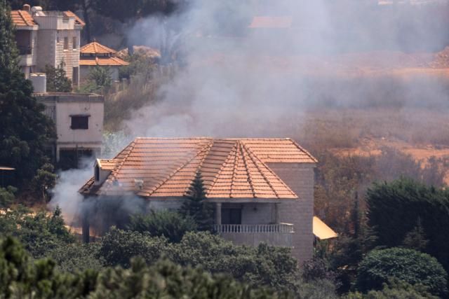 This picture taken from the southern Lebanese village of Zawtar al-Gharbiyah shows smoke billowing from a house in the Israeli-controlled nearby village of Zawtar al-Charkiyah on August 13, 2026. Lebanese Prime Minister Nawaf Salam on August 12 condemned Israel's "systematic destruction" in the country's south as a violation of international law, as Israel's defence minister said its military was "destroying all the houses" there. (Photo by Ammar Ammar / AFP) / 