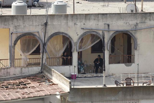 Women smoke waterpipe as they sit on their house's balcony in the southern Lebanese village of Zawtar al-Gharbiyah on August 13, 2026. Lebanese Prime Minister Nawaf Salam on August 12 condemned Israel's "systematic destruction" in the country's south as a violation of international law, as Israel's defence minister said its military was "destroying all the houses" there. (Photo by Ammar Ammar / AFP) / 